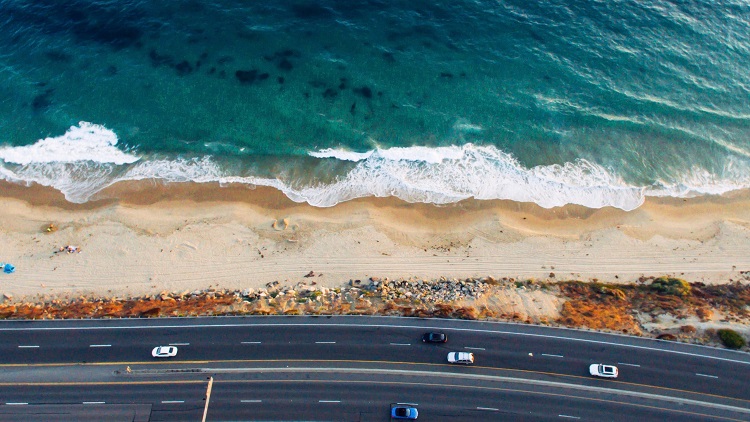 picture of cars driving on highway along ocean