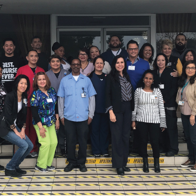 employees posing outside building