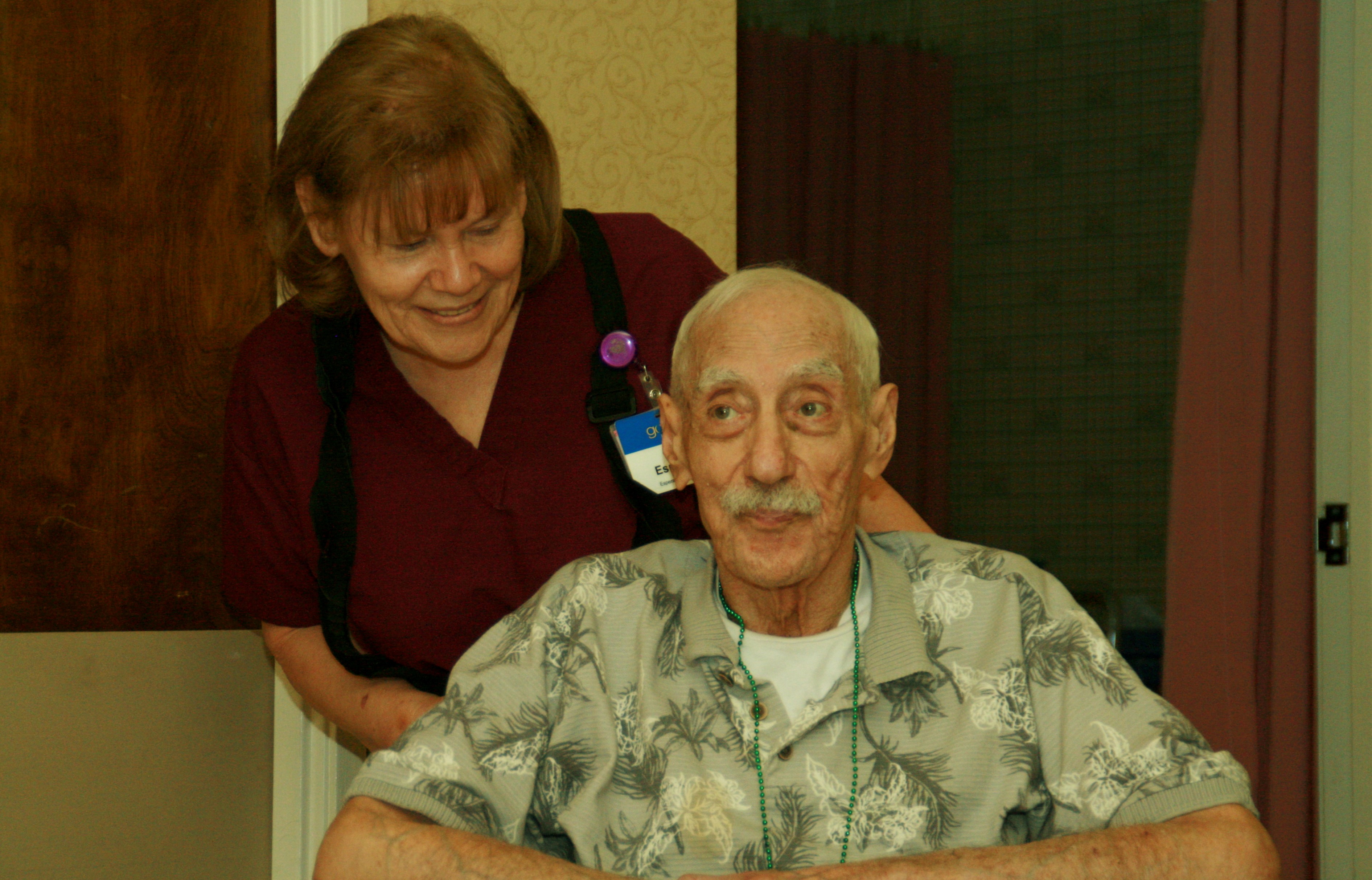 picture of man in wheelchair with woman behind him